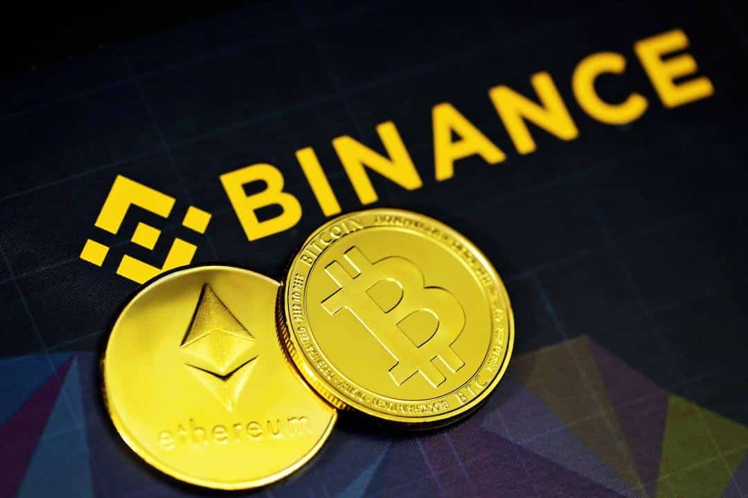 two gold bitcoins sitting next to a binance sign - Ethereum and Bitcoin next to the Binance logo, tags: crypto sec - unsplash